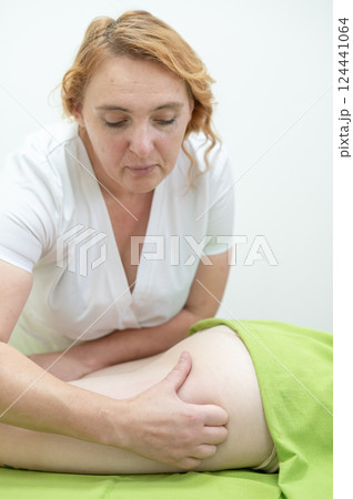 Anti-cellulite manual massage of thighs.  124441064