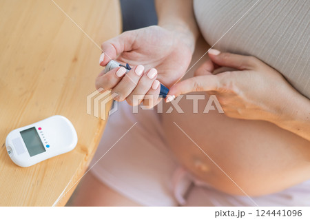 Pregnant woman doing home blood sugar test. Gestational diabetes. Pregnant woman doing home blood sugar test. Gestational diabetes. 124441096
