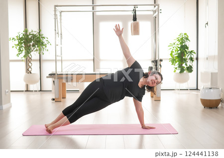 Fat woman doing yoga in studio. Fat woman doing yoga in studio. 124441138