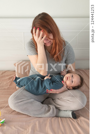 Vertical photo. A woman holds a child in her arms and cries. Postpartum depression. Vertical photo. A woman holds a child in her arms and cries. Postpartum depression. 124441253