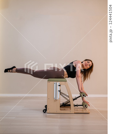 Asian woman doing pilates classic chair.  124441504