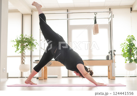 Fat woman doing yoga in studio. Fat woman doing yoga in studio. 124441556