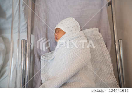 Newborn baby in diapers and a hat.  124441615