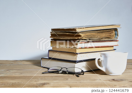 stack of books with a cup and glasses next to it. Space for text. The concept of training and education. stack of books with a cup and glasses next to it. Space for text. The concept of training and education. 124441679
