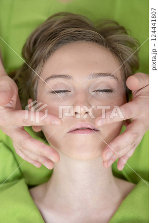 Top view of woman getting facial massage.  124441807