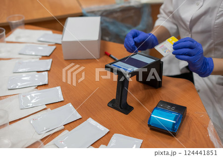 A narcologist tests urine for drugs using an electronic device.  124441851