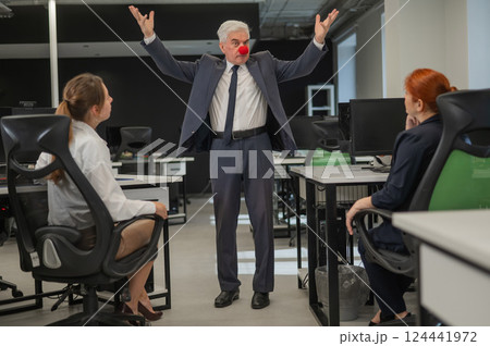 Elderly Caucasian man wearing a clown nose swears at his subordinates.  124441972