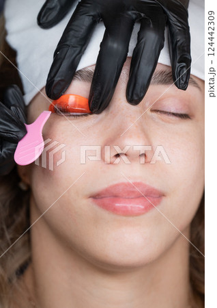 Caucasian woman undergoing eyelash lamination procedure.  124442309