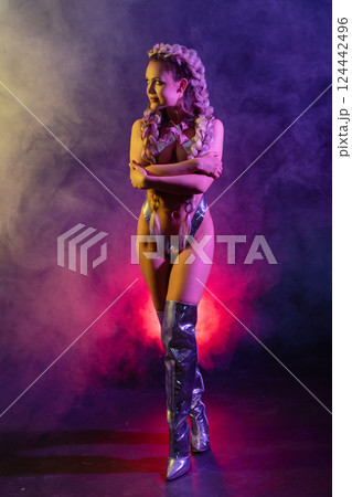 Woman showcases artistic body art with silver tape in lingerie at vibrant event 124442496