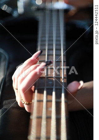 Girl Plays The Bass Sitting At The Table In A Natural Park 124442511