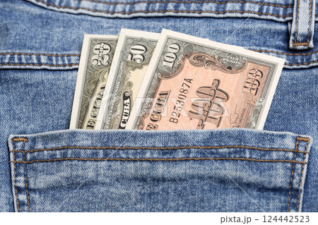 Old Cuban pesos in the pocket of blue jeans 124442523