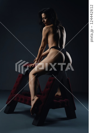 Woman Posing on Padded A-Frame bench prepared for bdsm game 124442612