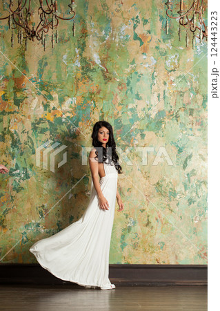 Beautiful young female model brunette looking at camera indoor, full length portrait Beautiful young female model brunette looking at camera indoor, full length portrait 124443223