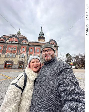 Couple taking selfie in front of historic town hall in Subotica in Serbia on a winter day. Travel, culture, architecture, and joyful relationship concept. East Europe Couple taking selfie in front of historic town hall in Subotica in Serbia on a winter day. Travel, culture, architecture, and joyful relationship concept. East Europe 124443228