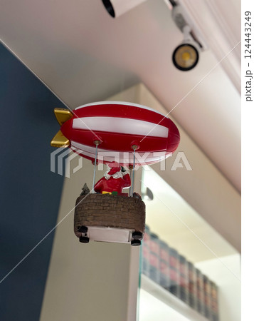 Santa flying a red and white zeppelin in whimsical holiday decor. Fantasy, imagination, and festive seasonal storytelling Santa flying a red and white zeppelin in whimsical holiday decor. Fantasy, imagination, and festive seasonal storytelling 124443249