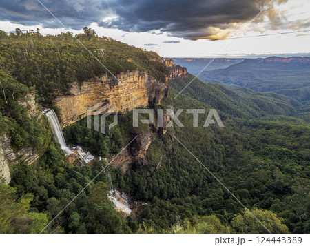 Waterfall and forested rocky mountains Waterfall and forested rocky mountains 124443389