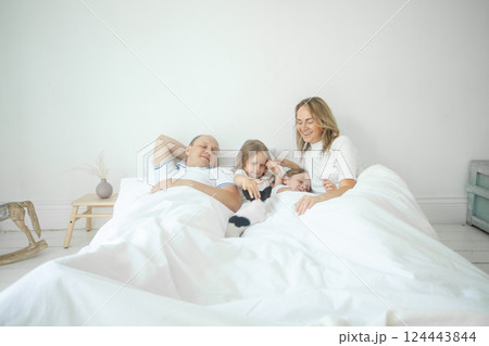 Relaxing family on the bed together at home Relaxing family on the bed together at home 124443844