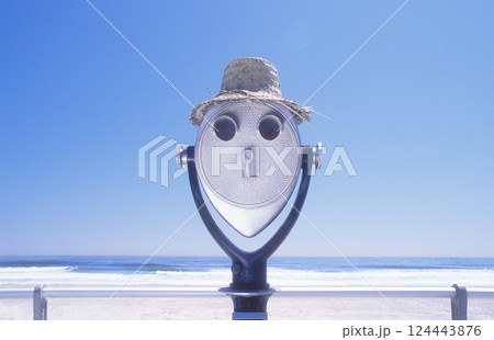 Coin-operated binoculars in straw hat on beach 124443876