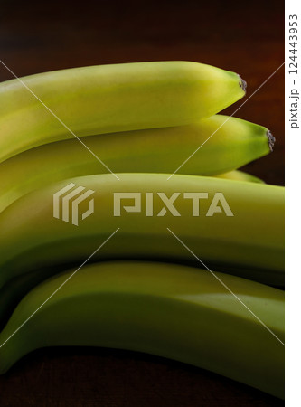 Close-up of fresh green bananas against black background Close-up of fresh green bananas against black background 124443953
