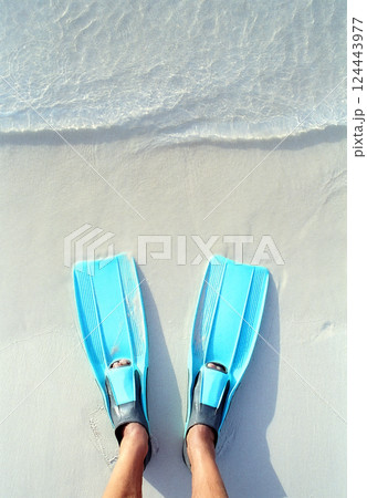 Mans legs with turquoise flippers on beach Mans legs with turquoise flippers on beach 124443977