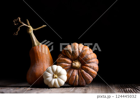 Autumn composition with three different pumpkins on wooden table 124445032