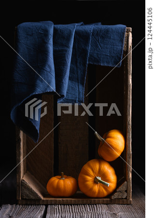 Three orange Baby Boo pumpkins squash in wooden box 124445106