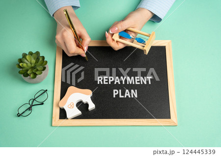 A repayment plan concept. Agreement between a borrower and a lender outlining how a debt will be repaid over time. A woman writes on a board near a house and holds an hourglass in her hands A repayment plan concept. Agreement between a borrower and a lender outlining how a debt will be repaid over time. A woman writes on a board near a house and holds an hourglass in her hands 124445339