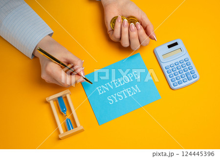 The Envelope System concept. Budgeting method that involves using physical envelopes to manage spending in different categories. Business and finance. A woman holds coins in hand, writes in a notebook 124445396
