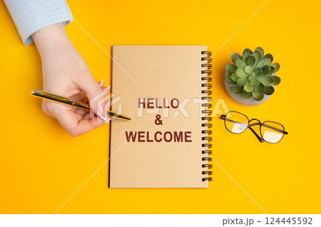 Hello and welcome concept. Friendly and polite greeting often used at the beginning of a conversation, meeting, or event. Warm reception. Woman writing a message in a notepad Hello and welcome concept. Friendly and polite greeting often used at the beginning of a conversation, meeting, or event. Warm reception. Woman writing a message in a notepad 124445592