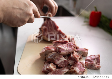 Chopping Fresh Meat for Cooking in the Kitchen for your Delicious Meals and Recipes 124446635