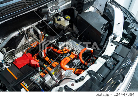 Electric car with open hood. Close up of inverter and wires 124447384