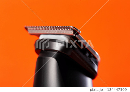 beard trimmer on a red background, close-up. Hair and beard care, close-up beard trimmer on a red background, close-up. Hair and beard care, close-up 124447509