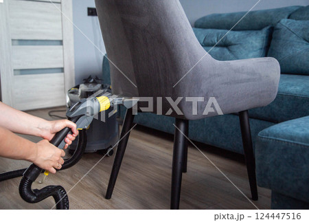 Dry cleaning services, washing and cleaning gray fabric chairs with a washing vacuum cleaner, industry. Dry cleaning services, washing and cleaning gray fabric chairs with a washing vacuum cleaner, industry. 124447516