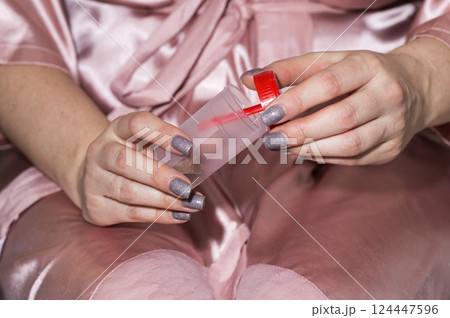 A container with a stool test is in the girl s hands. Concept for studying stool analysis in gastroenterology, coprogram, close-up A container with a stool test is in the girl s hands. Concept for studying stool analysis in gastroenterology, coprogram, close-up 124447596