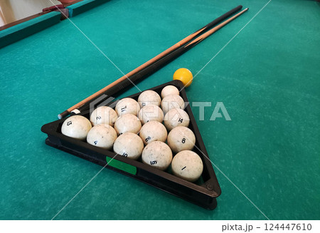 Balls with a cue lie on the green cloth of a billiard table, background. Copy space for text 124447610