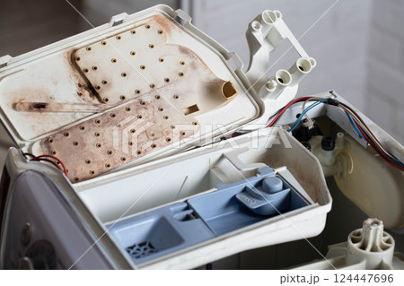 Disassembling the powder tray in the washing machine. Cleaning from dirt, mold and mildew, industry 124447696