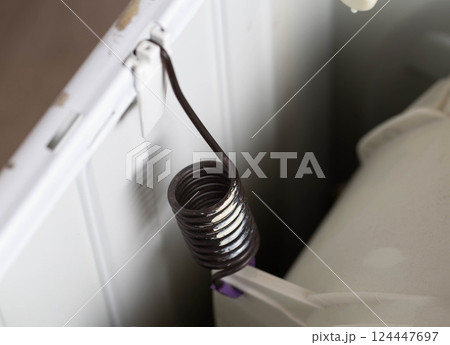 suspension spring of the washing machine tank to dampen vibration when spinning the washing machine. Breakdown and replacement of spare parts, copy space for text suspension spring of the washing machine tank to dampen vibration when spinning the washing machine. Breakdown and replacement of spare parts, copy space for text 124447697