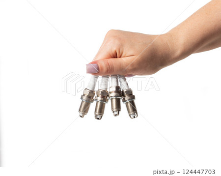 Car spark plugs in a girl's hand on a white background, isolate. Close-up Car spark plugs in a girl's hand on a white background, isolate. Close-up 124447703