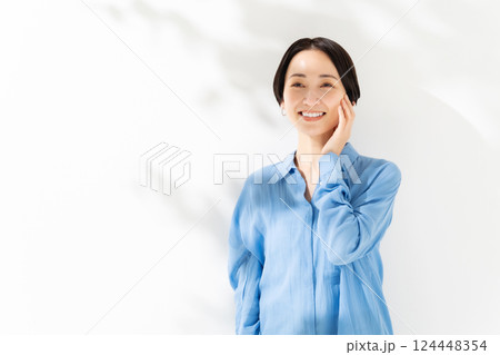 頬を触る女性 木漏れ日 ビューティー 頬を触る女性 木漏れ日 ビューティー 124448354
