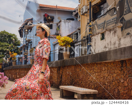 woman in dress and hat exploring vibrant streets of Malacca, Malaysia. woman in dress and hat exploring vibrant streets of Malacca, Malaysia. 124448416