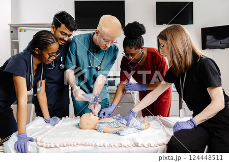 Medical Students Practicing Intubation Technique on Baby Mannequin during Training 124448511