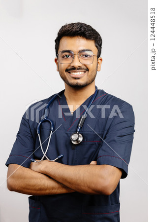 Portrait of a smiling Indian doctor wearing glasses and stethoscope with arms crossed 124448518