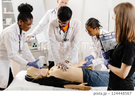 Doctors practicing cardiopulmonary resuscitation on a medical manikin Doctors practicing cardiopulmonary resuscitation on a medical manikin 124448567