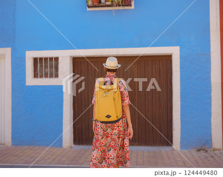 Woman strolls through colorful streets of Spanish coastal town 124449480