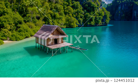 A small wooden house on stilts in the middle of a body of water 124451012