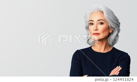 smart woman, A confident older woman with silver hair poses thoughtfully, wearing a dark sweater 124451824