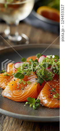 Thinly sliced salmon carpaccio appetizer garnished with fresh microgreens, sesame seeds, and a drizzle of olive oil Thinly sliced salmon carpaccio appetizer garnished with fresh microgreens, sesame seeds, and a drizzle of olive oil 124453327