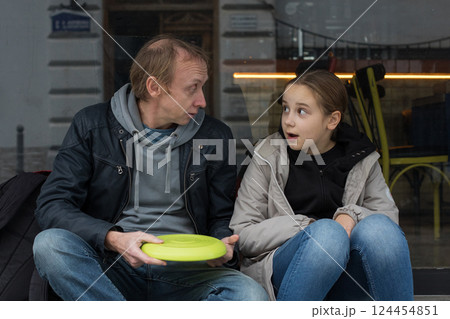 Outdoors portrait of father and daughter talking together. Happy family Outdoors portrait of father and daughter talking together. Happy family 124454851