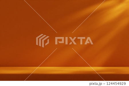 Orange studio room wall, illuminated by sunlight through foliage with tabletop. Product presentation template. 124454929