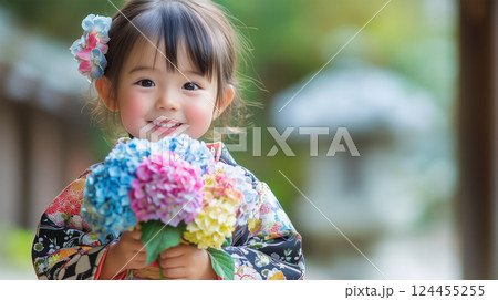 小さな手で紫陽花を抱え、純粋な笑顔を見せる女性 124455255